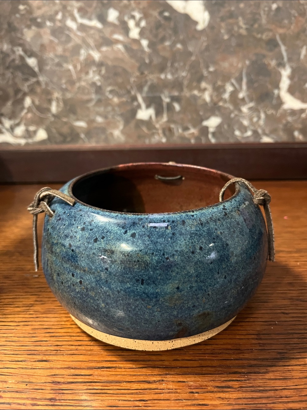 Handcrafted ceramic bowl with a mottled blue and brown speckled glaze